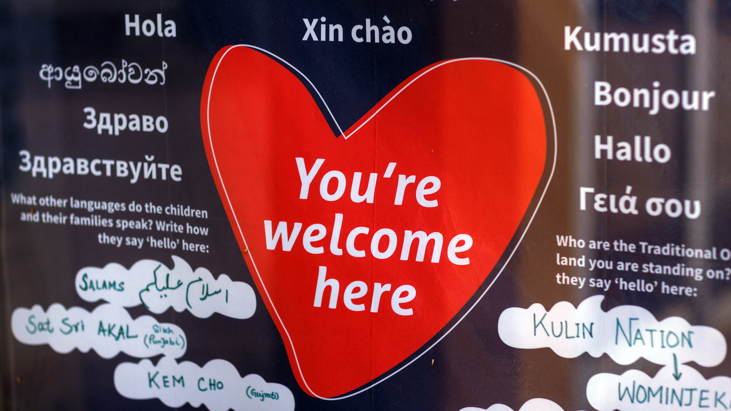 An image of a love heart with the words 'You're welcome here' written on it, surrounded by the word 'Hello' written in different languages.