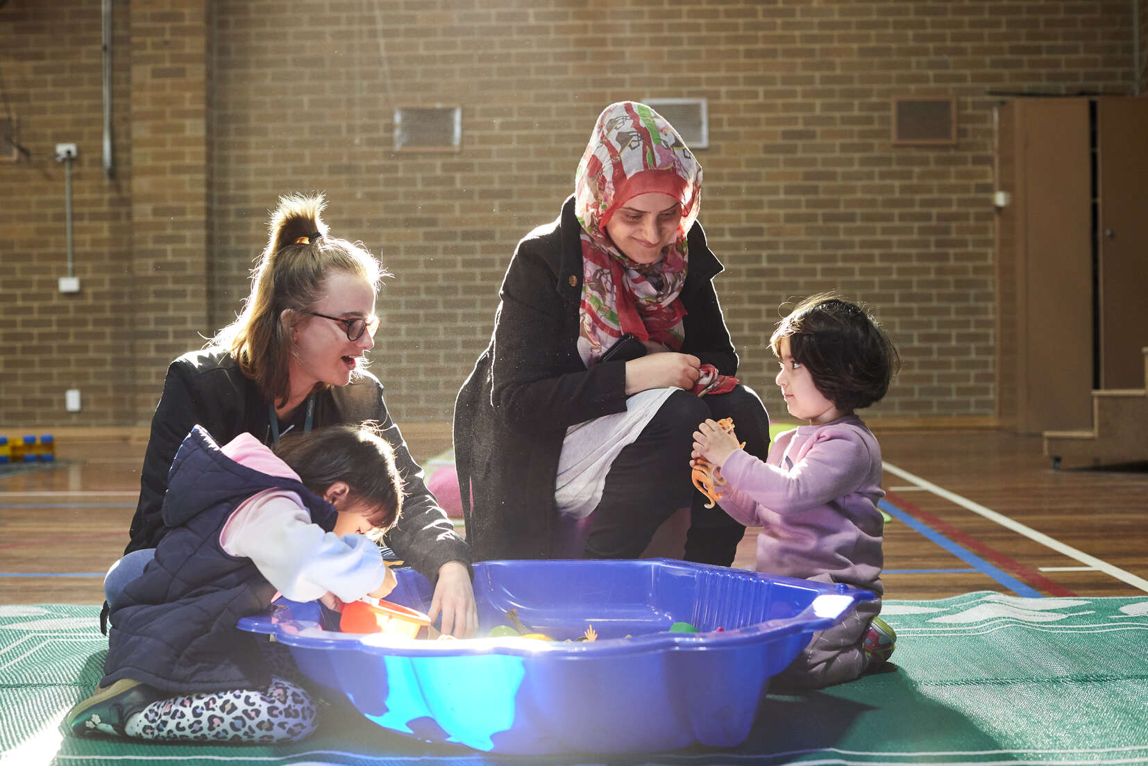 Two educators playing with young children